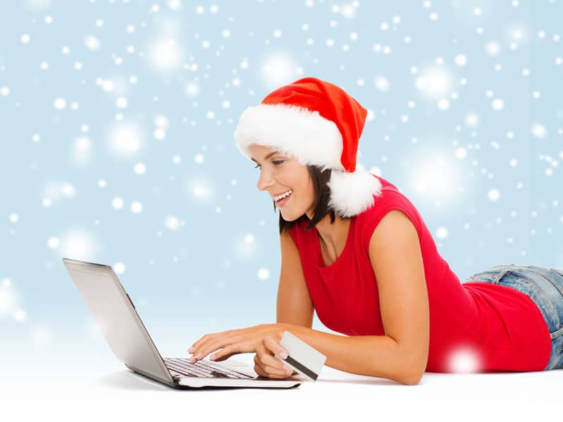 woman in santa hat with laptop and credit card
